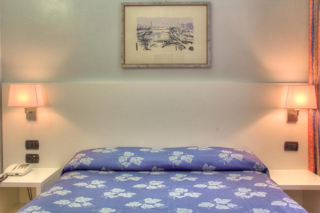 una camera con un letto e una foto appesa al muro di Hotel Pico a Mirandola