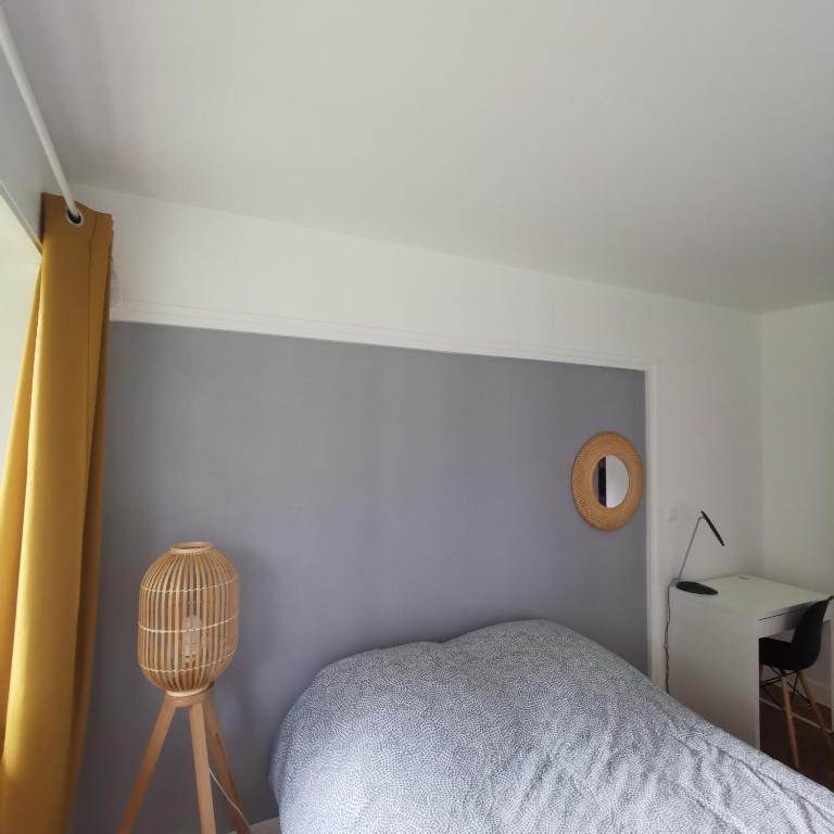 une chambre avec un lit et un mur blanc dans l'établissement Chambre confort Saint Marceau, à Orléans