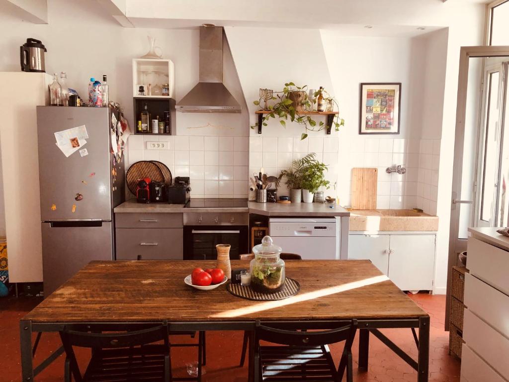 - une cuisine avec une table en bois et des fruits dans l'établissement T2 Vauban Marseille, à Marseille