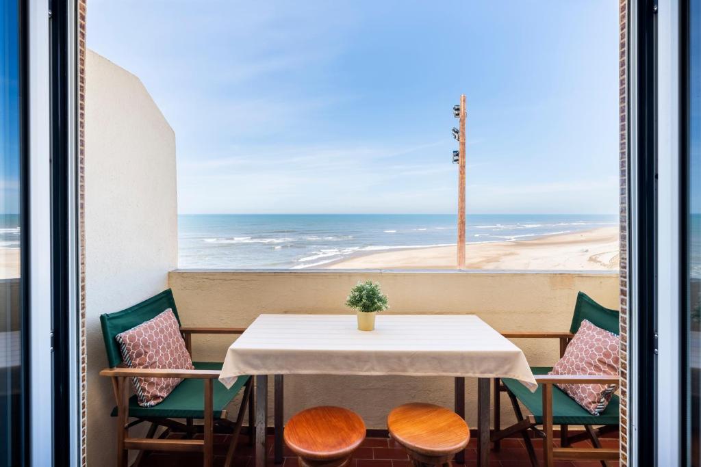 une table et des chaises avec vue sur l'océan dans l'établissement Pedrógão Sea View, à Pedrógão