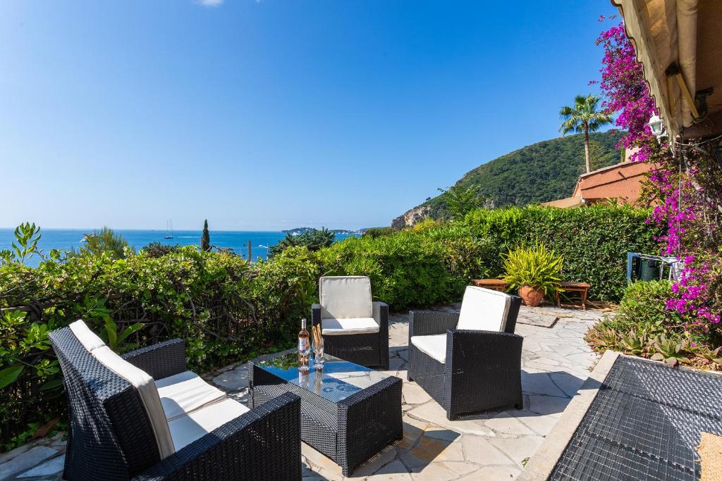 un patio avec des chaises et une table et l'océan dans l'établissement VILLA LA PETITE RESERVE VI4416 By Riviera Holiday, à Èze