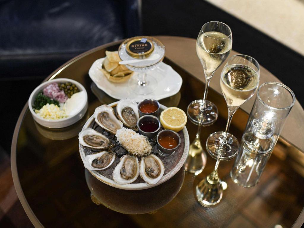 a table with a plate of oysters and glasses of wine at Fairmont Royal York Hotel in Toronto