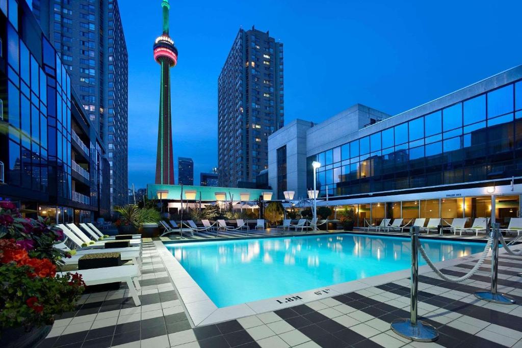 a pool in a city with a tower in the background at Radisson Blu Toronto Downtown in Toronto