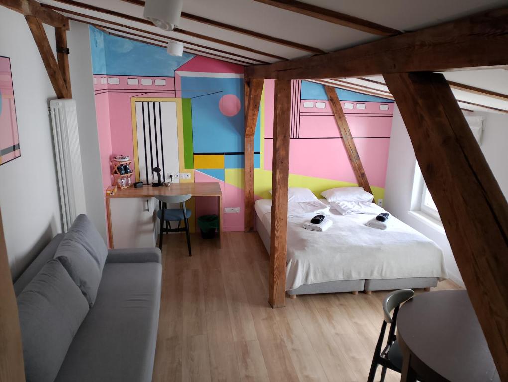 a bedroom with a bed and a desk and a table at So in Sopot Station in Sopot