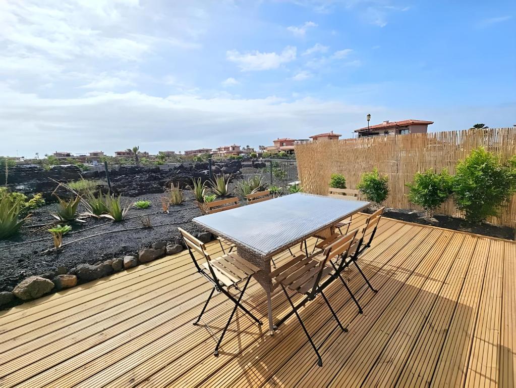 a table and chairs on a wooden deck at Casa Topik, Family and Surfhouse in Majanicho