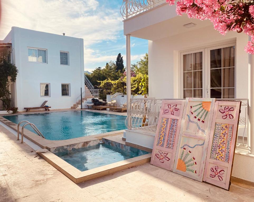 a villa with a swimming pool in front of a house at Bodrum Nuran Boutique Apart in Bodrum City