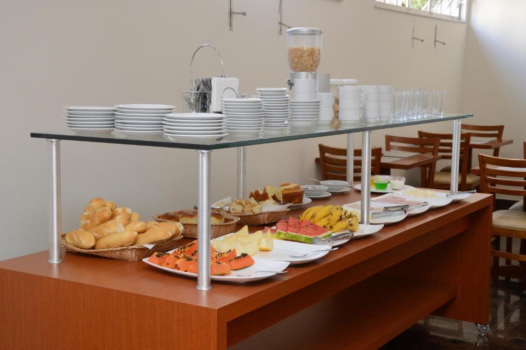 a buffet with plates and food on a table at Hotel Giordano Centro in São João da Boa Vista