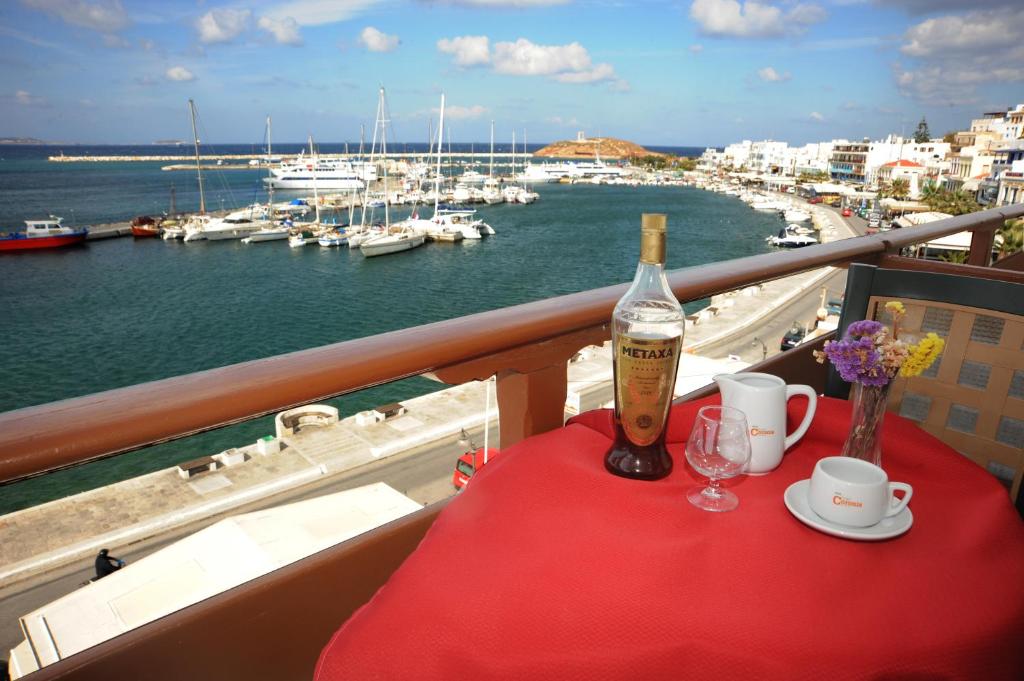 uma mesa com uma garrafa de vinho e copos numa varanda em Hotel Coronis em Naxos Chora