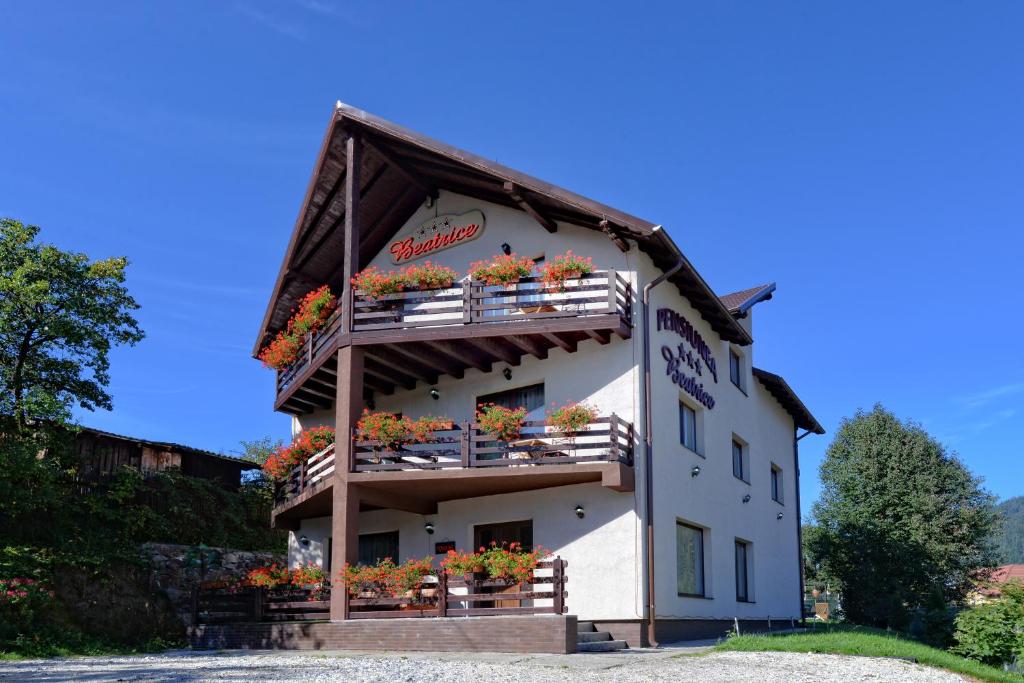a building with flowers on the balconies of it at Pensiunea Beatrice in Vatra Dornei