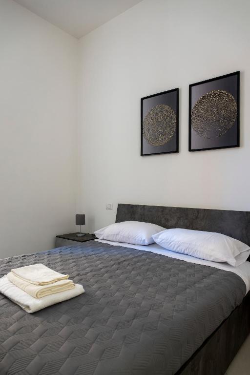a bedroom with a large bed with three pictures on the wall at Casa Vacanze Nemesi TYCHE in Salerno