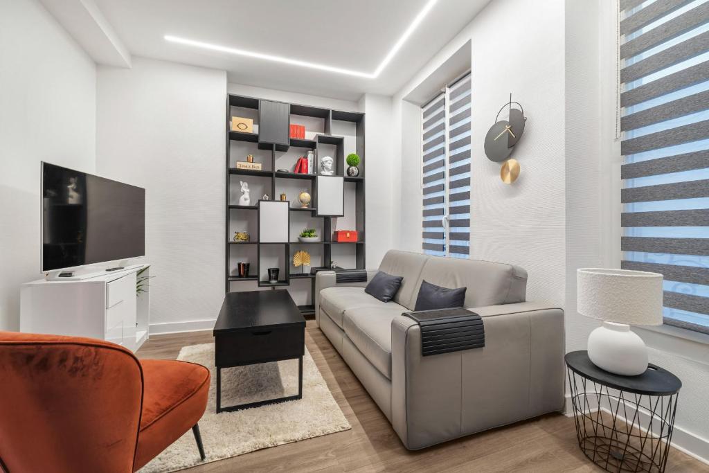 un salon avec un canapé et une télévision dans l'établissement Par Amour, à Paris