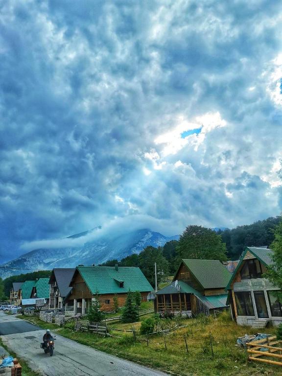 a kite is flying in the sky over a village at Montenegro High Mountain Apartment in Žabljak