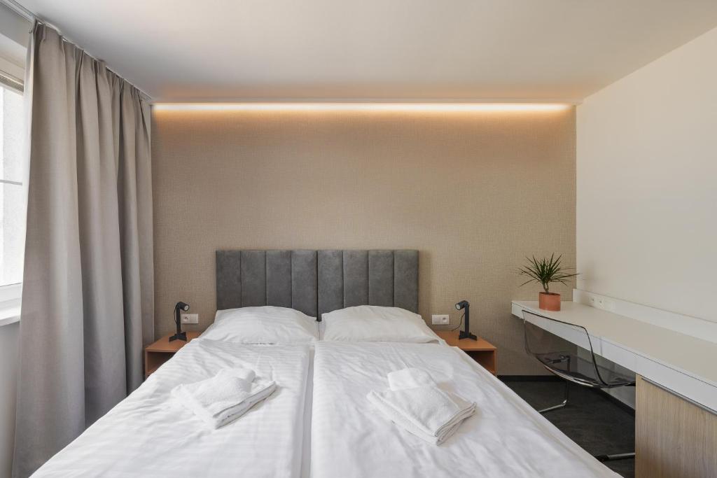 a bedroom with a large bed with white sheets at Hotel Taxis Bratislava in Bratislava