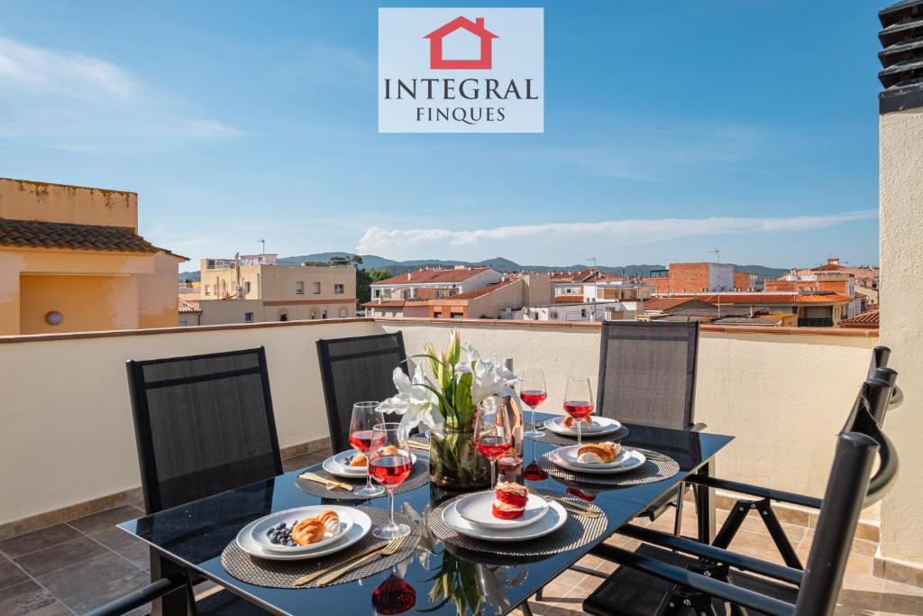 a table with food and wine glasses on a balcony at Golden Hour Palamós in Palamós