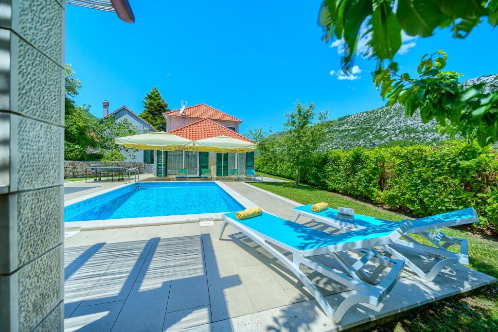 a villa with a swimming pool and a house at Villa Župa - Heated Pool, Tennis & Sports Complex in Župa