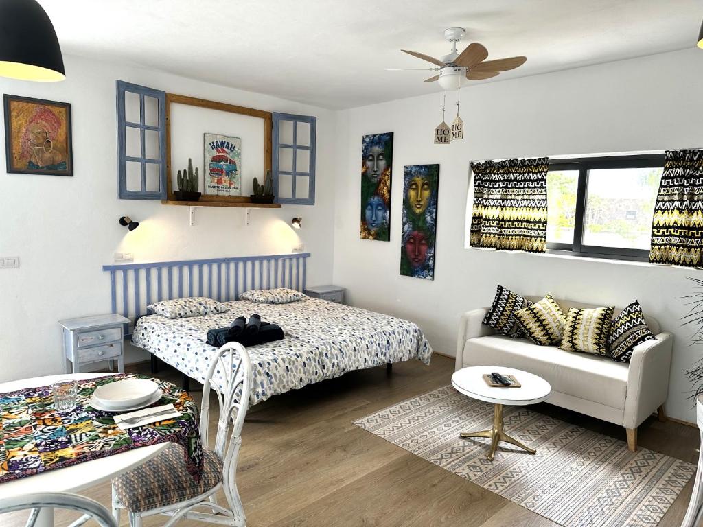 Un dormitorio con una cama y un sofá en una habitación. en Casita Tiaré Lajares, en Lajares
