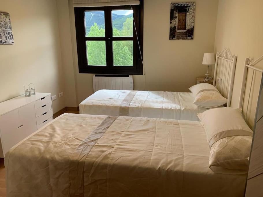 a bedroom with two beds and a window at Alojamiento fiordos leoneses Boñar in Boñar