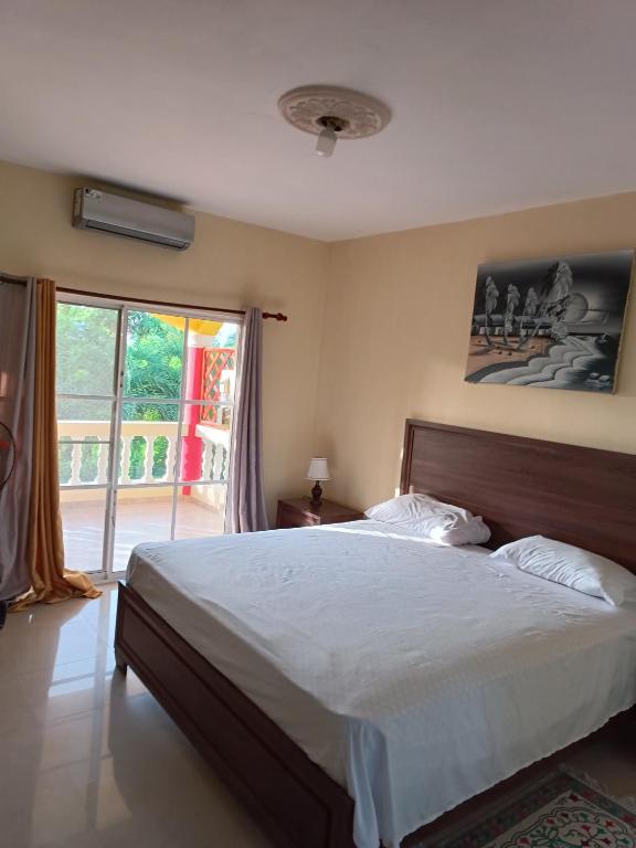 a bedroom with a large bed and a large window at TropicalHouse in Punta Cana