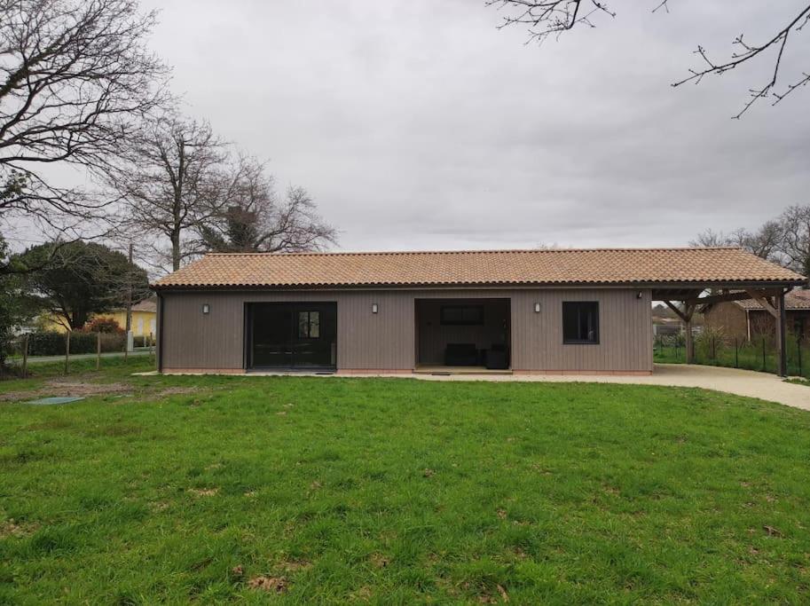 un petit bâtiment avec une cour herbeuse devant lui dans l'établissement La maison de Grayan !, à Grayan-et-lʼHôpital