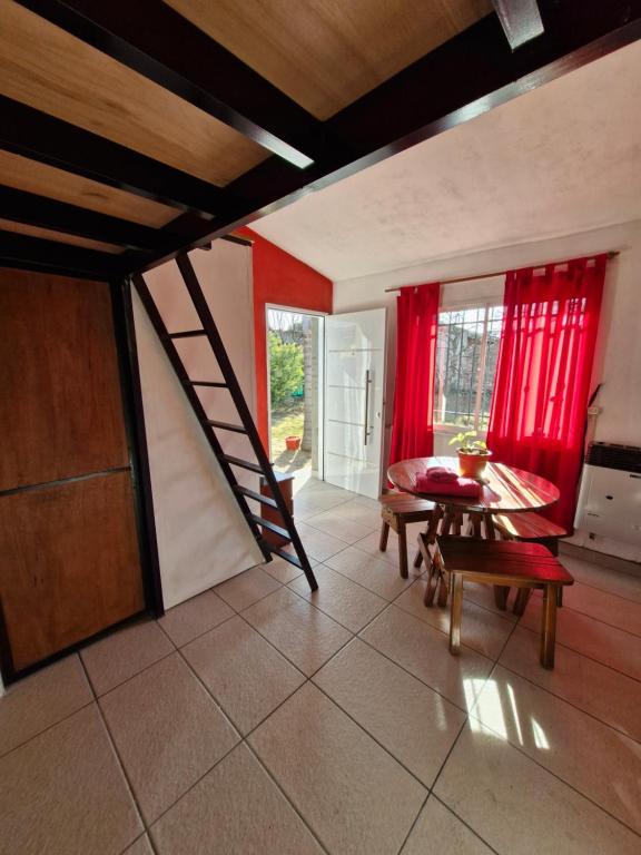 un salon avec un escalier et une table dans l'établissement LOFT Huayna picchu, à La Falda