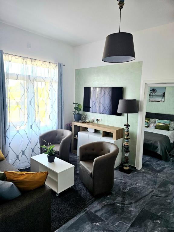 a living room with a couch and chairs and a bed at Apartman Istria Green in Kaštel