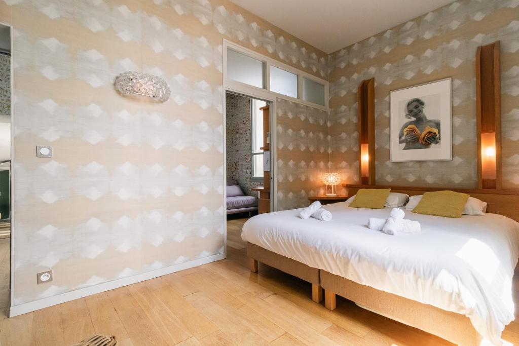 une chambre avec un grand lit dans une pièce dans l'établissement Chartreuse du Parc - Quartier Caudéran, chic et calme, Grande Terrasse 2 chambres avec Parking, à Bordeaux