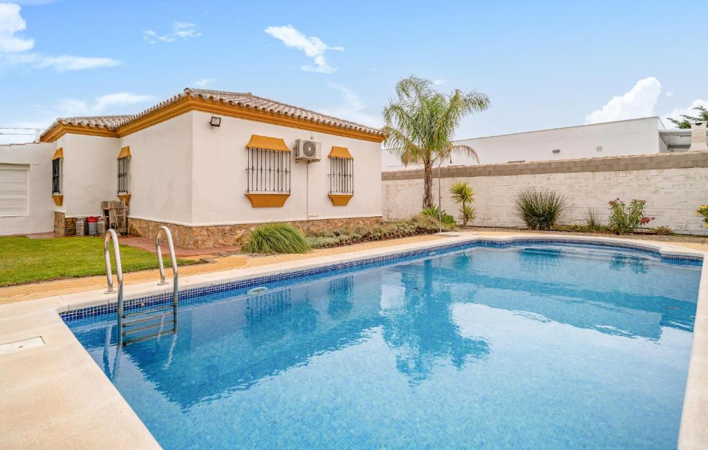 a swimming pool in front of a house at Lovely Home In Chiclana De La Fronter in Chiclana de la Frontera
