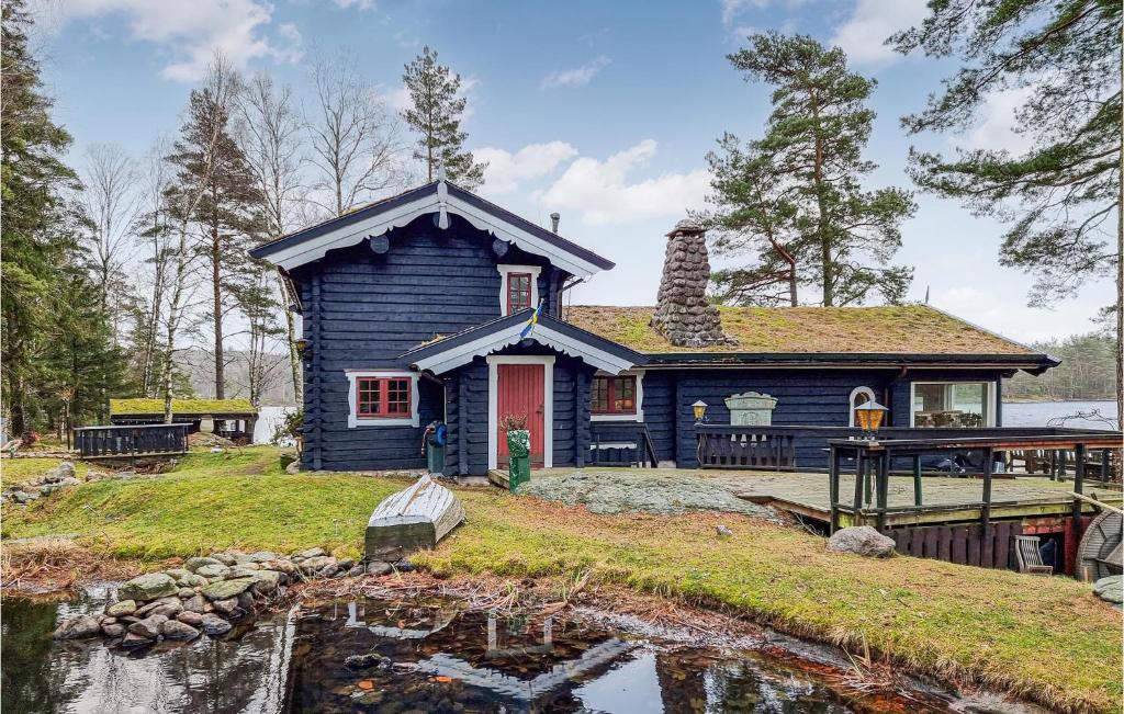 a blue house with a pond in front of it at Nice Home In Nol With House Sea View in Nol