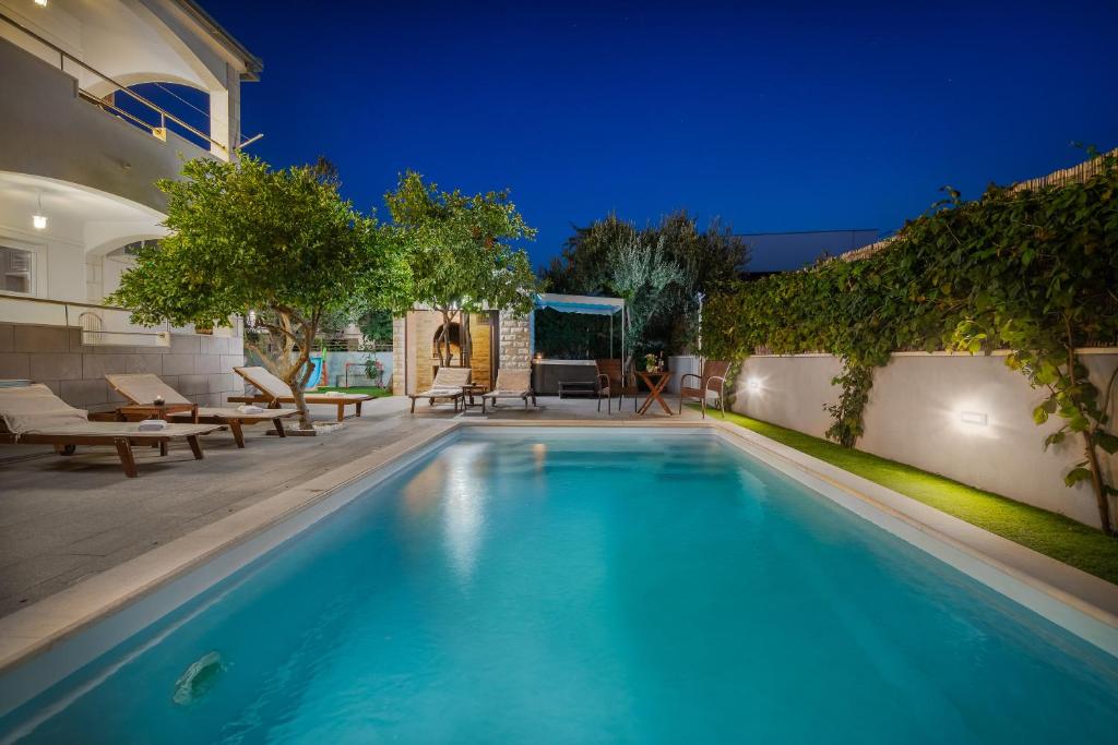 ein Swimmingpool im Hinterhof eines Hauses in der Unterkunft Sunshine Holiday Home in Kaštela