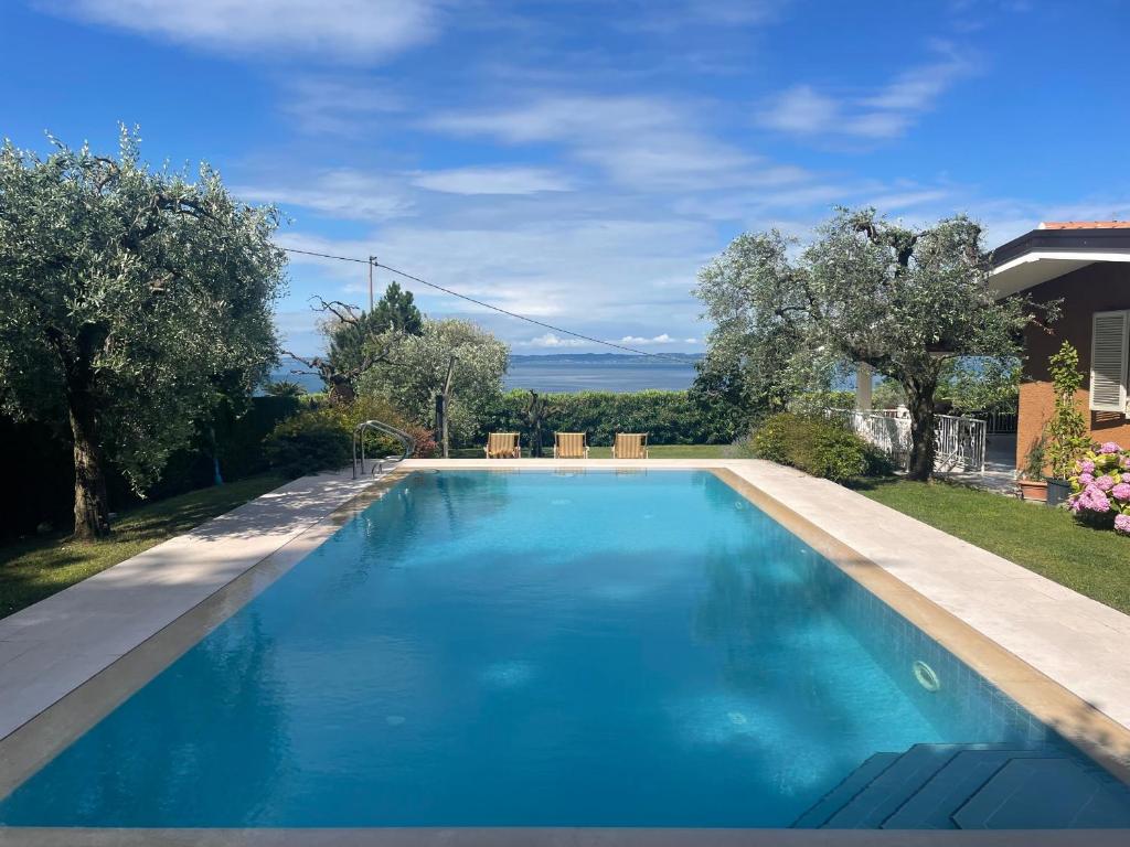 a swimming pool with blue water in a yard at Villa Cà Brusà in Bardolino