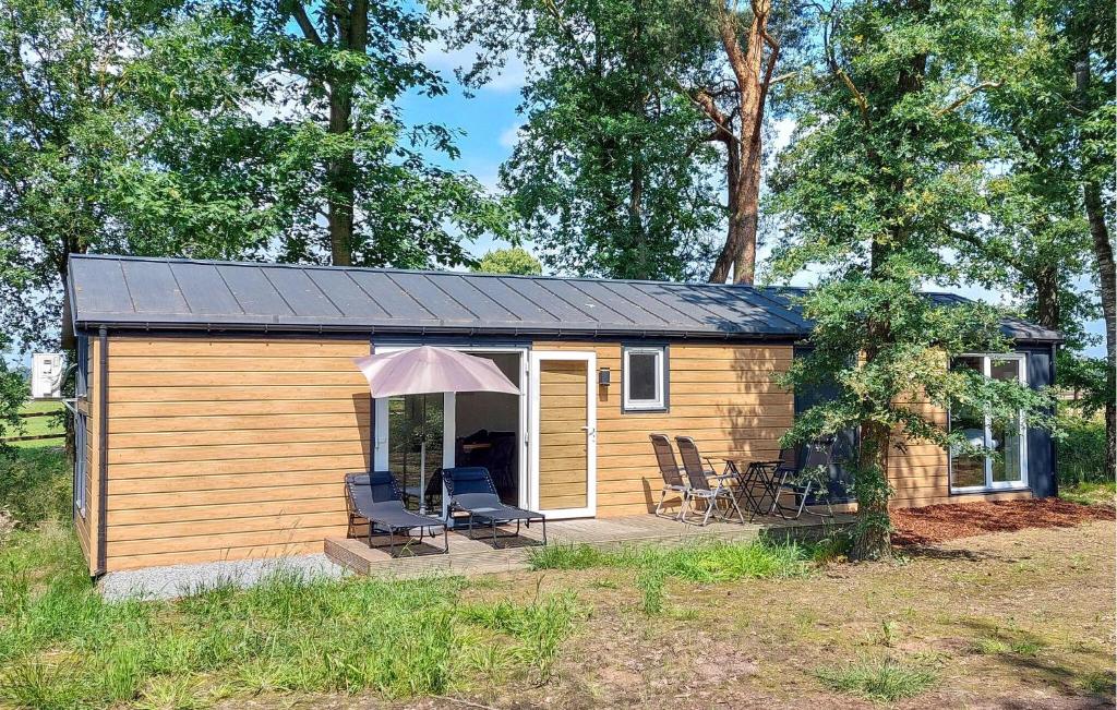 a small cabin with two chairs and an umbrella at Lovely Home In Hellendoorn With Wifi in Hellendoorn