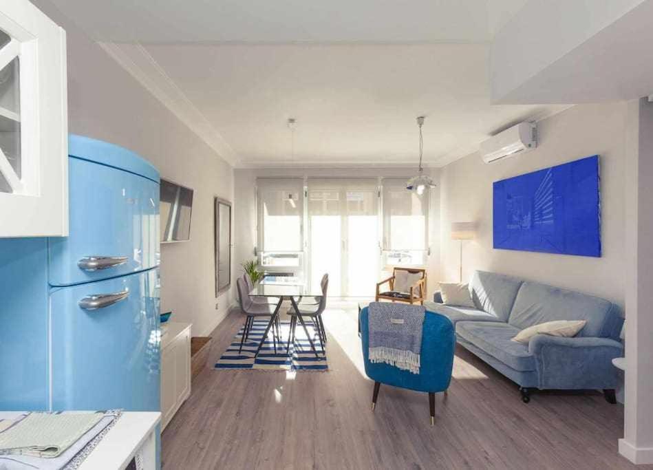 a living room with a blue couch and a table at GuardaViñas24 in Logroño