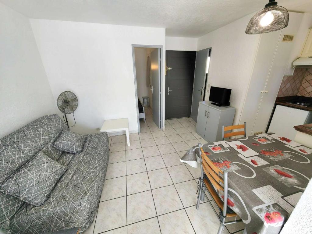 un salon avec un canapé et une table dans l'établissement Charmant T2 en Pinède avec parking, véranda et terrasse, à 900m de la plage, idéal pour 4 personnes - FR-1-607-41, au Cap d'Agde