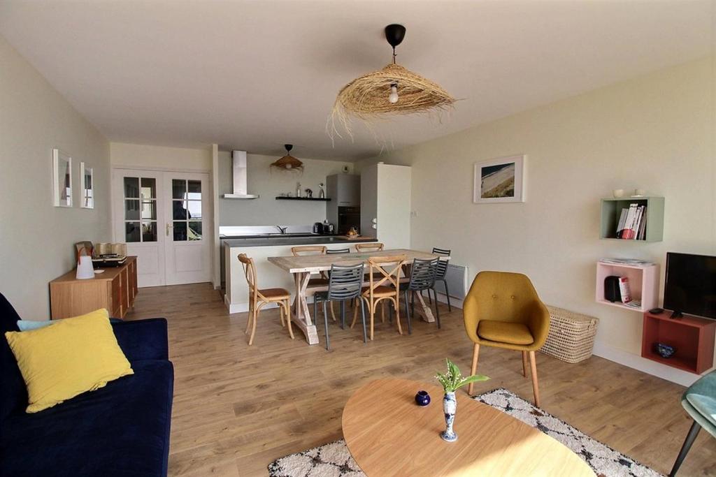 Una sala de estar y una cocina con mesa y sillas. en Annonce professionnelle. Appartement en rdc face mer, 2 chambres pour 4 à 6 personnes HARDELOT, en Hardelot-Plage