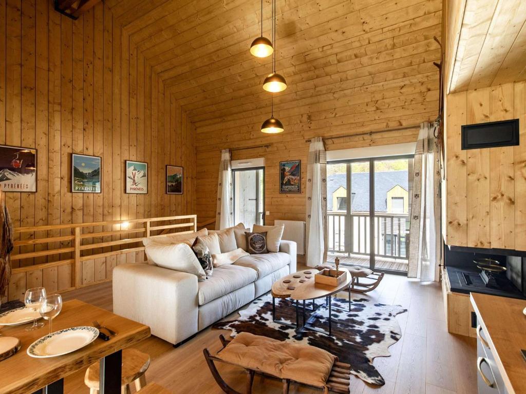 un salon avec un canapé et une table dans l'établissement Lodge neuf avec grande terrasse et équipement haut de gamme - FR-1-401-292, à Cauterets