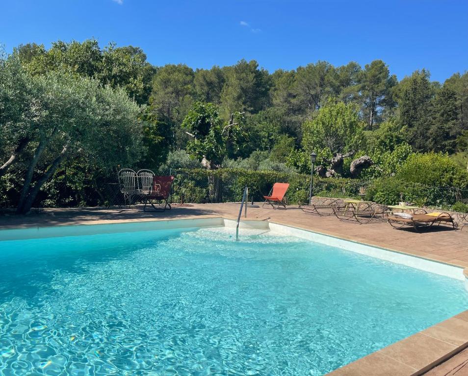 une piscine avec de l'eau bleue dans une cour dans l'établissement Les bergeries de DANIELLE, à Draguignan