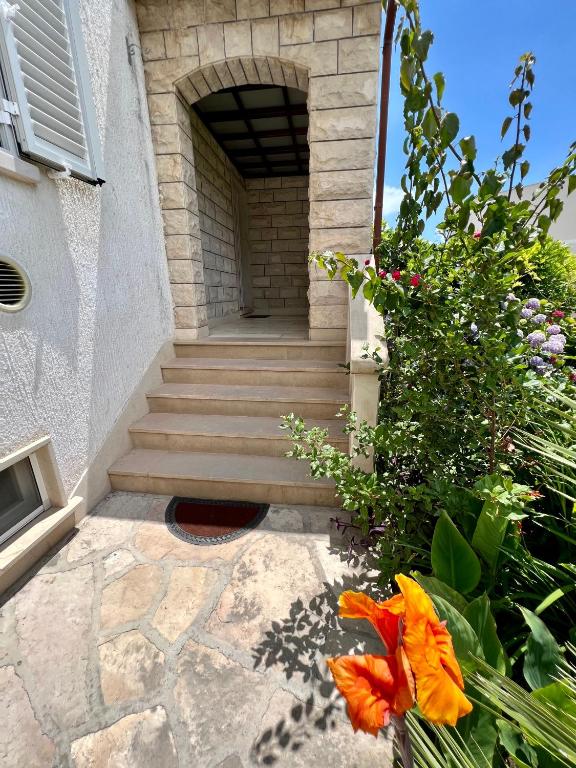 a staircase leading to a building with flowers at Vila Vera Seafront Apartments in Sumartin