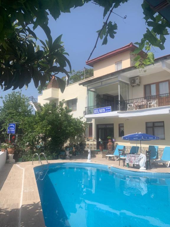 a swimming pool in front of a building at Kristal pansiyon in Ortaca