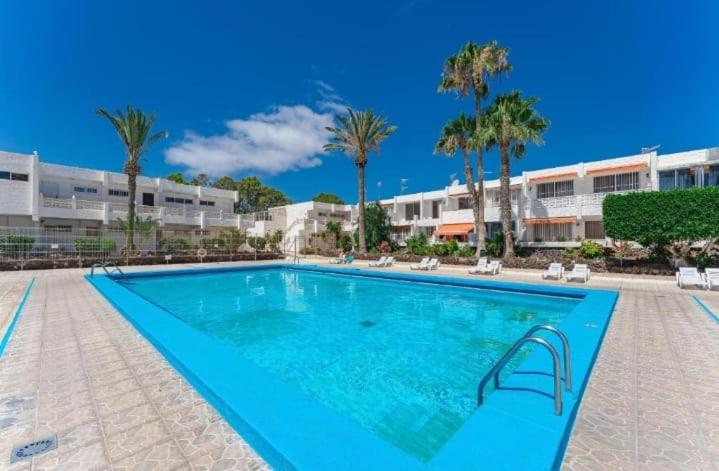 ein großer Swimmingpool in einem Resort mit Palmen in der Unterkunft MARINE HOME in Costa Del Silencio