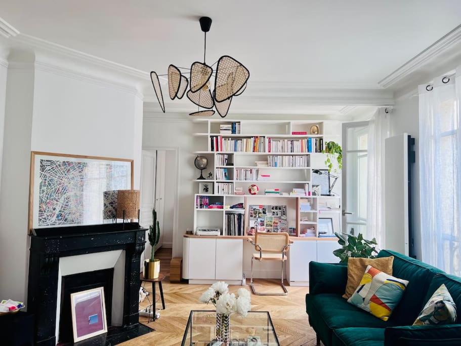 - un salon avec un canapé vert et une cheminée dans l'établissement Appartement cosy Batignolles, à Paris