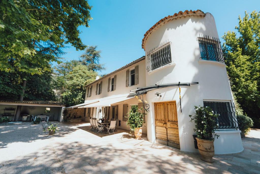 - un bâtiment blanc avec une porte et une cour dans l'établissement Domaine de Roquepertuse, à Velaux