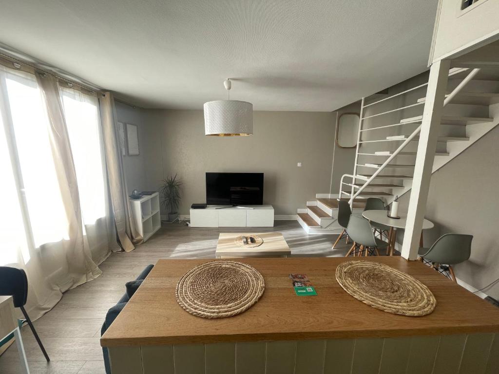 a living room with a staircase and a table at magnifique Duplex avec 2 chambres et parking gratuit in Grenoble