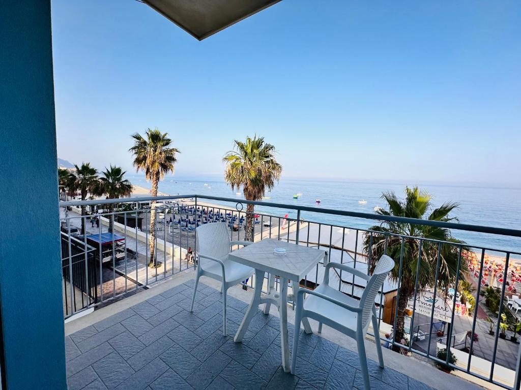 a balcony with a table and chairs and the ocean at Maniel Beach Hotel in Letojanni