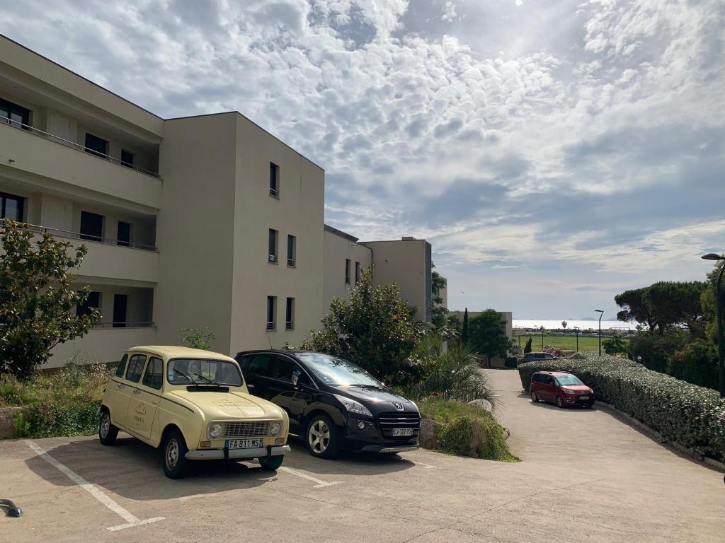 une vieille voiture garée dans un parking à côté d'un bâtiment dans l'établissement T2 de standing à Porticcio, proche plage et commerces, à Grosseto-Prugna