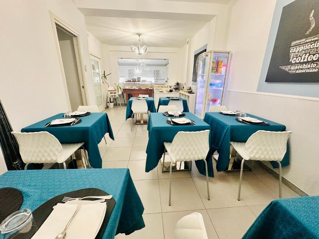 a dining room with blue tables and chairs at Maniel Beach Hotel in Letojanni