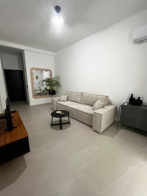 un salon blanc avec un canapé et une table dans l'établissement Magnifique T2 cœur de ville, à Sète