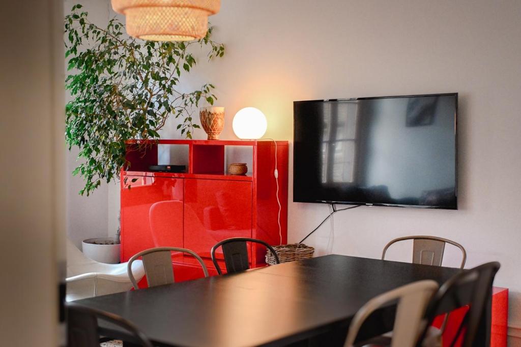 d'une salle à manger avec une table et une télévision à écran plat. dans l'établissement Les Appartements Rue des Veaux - Quartier Cathédrale, à Strasbourg