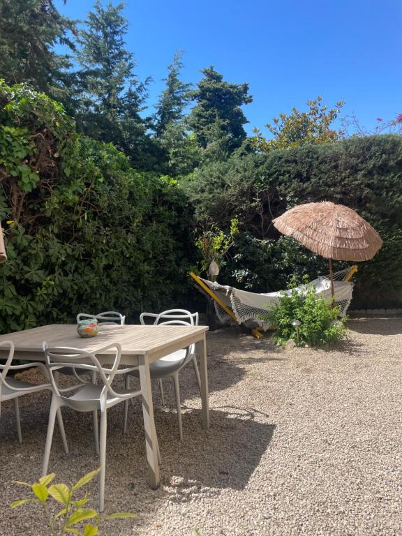 - une table et des chaises avec un parasol et un hamac dans l'établissement Bel appartement Cap d Antibes avec terrasses et jardins, à Antibes