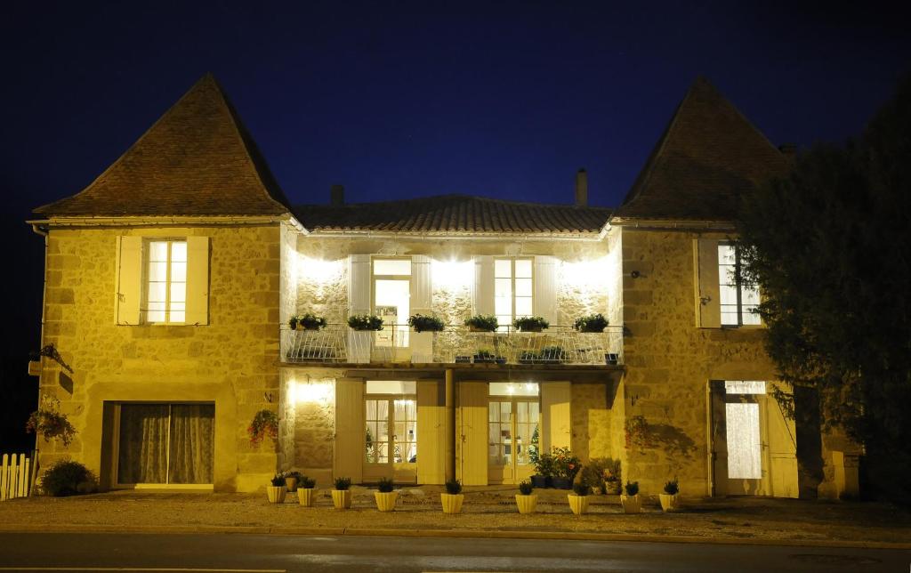 Saint-Colomb-de-LauzunにあるChez Madeleineの夜間照明付きの大きなレンガ造りの家