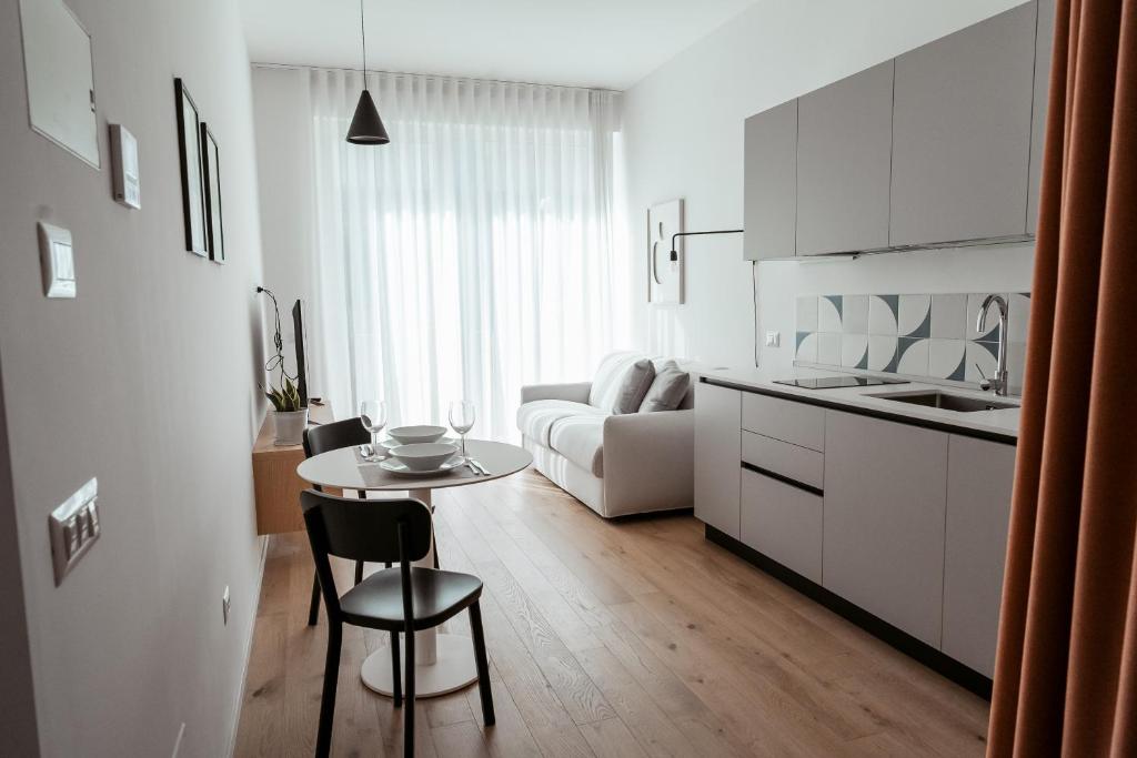 a kitchen and a living room with a table and chairs at Paramar Casa Vacanza Conversano in Conversano